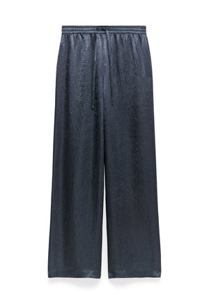 Wijde broek gemaakt van textiel met een glanzend zwart materiaal. Beschikt over een elastische tailleband met een trekkoord en heeft een ontspannen pasvorm.