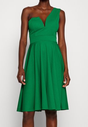 Grøn kjole med en enkelt skulderdesign, dyb V-hals, struktureret overdel og en flagrende nederdel med læg, lavet af tekstureret stof.