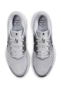 Szare i białe buty sportowe z siateczkowym wierzchem, płaskimi sznurowadłami i gumowymi podeszwami. Wyróżniające się czarne logo Swoosh po bokach.