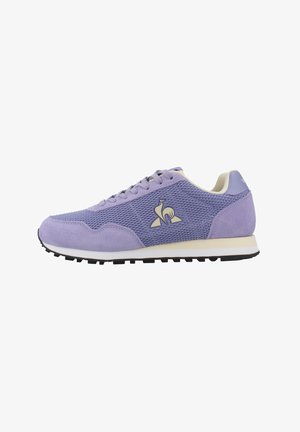 Zapatilla deportiva morada con materiales de malla y ante, puntera redonda, diseño con cordones y una entresuela blanca contrastante con una suela de goma negra.
