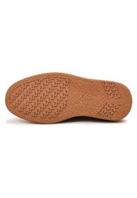 Semelle de chaussure en caoutchouc marron avec un motif texturé antidérapant, comprenant des crêtes et des rainures pour l'adhérence. Marquage de la taille « 39 » sur la semelle.