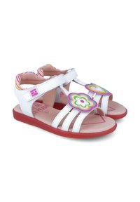 Sandalias blancas con acentos florales y en forma de corazón, tres correas, suela roja y forro interior rosa con un patrón de rayas colorido.