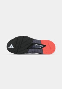 Black and orange athletic shoe sole with textured patterns, featuring a prominent Traxion logo and a smooth, supportive design.