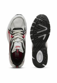 White and red athletic shoes with mesh upper, black accents, thick black rubber outsole, and textured tread patterns. Laces in white.