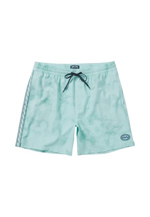 Bañadores de color verde claro con cordón ajustable, acentos de patrón en los lados y un pequeño parche de logo en la parte inferior de la pierna derecha. Textura suave.