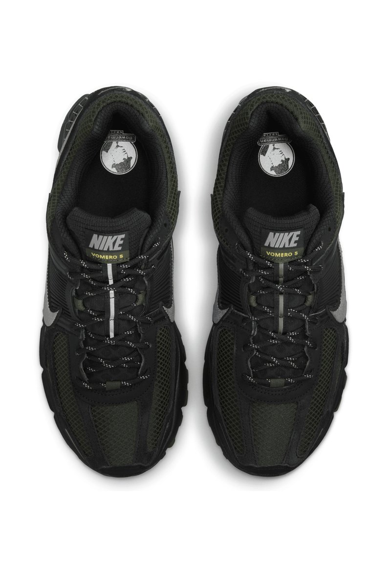 Baskets Nike Vomero 5 noires et vert foncé, réalisées en matériaux en mesh et textile, avec des accents réfléchissants et une semelle rembourrée.