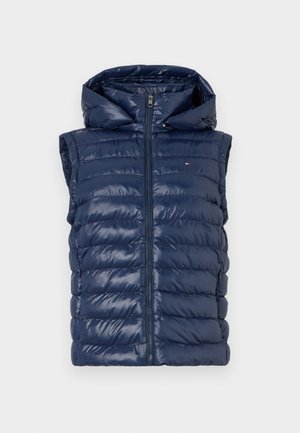 Mörkblå pufferväst med huva, försedda med quiltad vaddering, en dragkedja fram och en logodetalj på bröstet. Slät, glänsande yta.