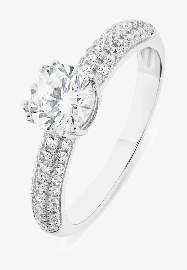 Bague en or blanc mettant en valeur un grand diamant rond central, entouré de petits diamants sur la bande, créant un effet scintillant.