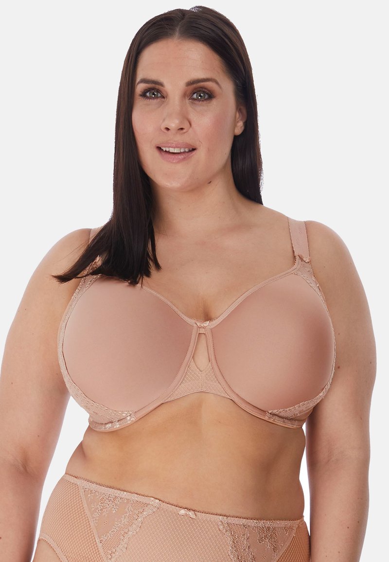 Reggiseno beige con stecche e coppe lisce, con dettagli in pizzo, spalline regolabili e un'apertura a chiave al centro davanti.