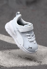 Weiße Kleinkind-Sneaker mit einem oberen aus Mesh, elastischen Schnürsenkeln und Klettverschluss, gepolstertem Schaft und strukturiertem Außensohlen. Schwarzes Puma-Logo an der Seite.