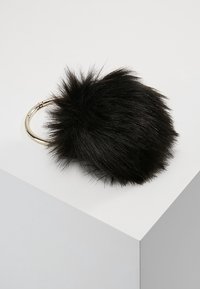 Sort faux fur pom-pom fastgjort til en metalgylden nøglering, med en rund form og blød, fluffy tekstur.