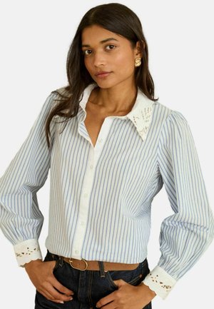 Blau-weiß gestreiftes Langarmhemd mit weißem Spitzenbesatz an Kragen und Manschetten, ausgestattet mit einer Knopfleiste vorne und einem lockeren Schnitt.