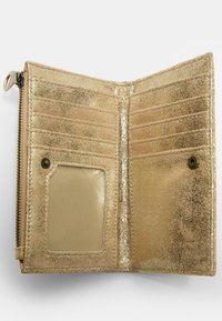 Zlatá metalická podšívka peněženky s několika přihrádkami na karty, průhledným okénkem na identifikaci a strukturovaným povrchem. Zapínání na zip po jedné straně.