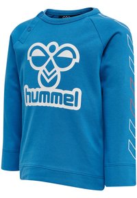 Blå langærmet sweatshirt med et stort hvidt logo på forsiden, trykknaplukning på skulderen og geometriske detaljer på ærmerne.