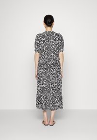 Schwarz-weißes Tiermuster Midikleid mit Puffärmeln und gestuftem Rock, aus leichtem Stoff gefertigt.