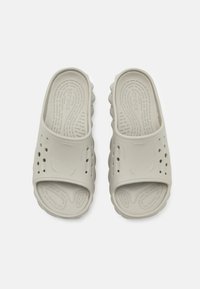 Light gray slip-on sandals made of textured rubber, featuring ventilation holes, a contoured footbed, and a grooved outsole for traction.