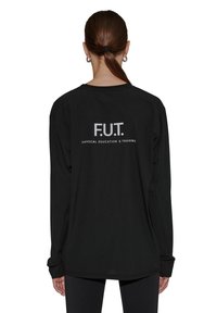 Sort langærmet skjorte med rund halsudskæring, med "F.U.T. FYSISK UDDANNELSE & TRÆNING" trykt i hvid på ryggen. Simpelt design.