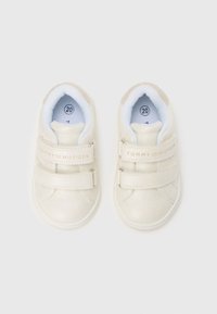 Adidași albi pentru copii mici din piele texturată, cu curele Velcro și căptușeală interioară albastră. Prezintă brandingul „TOMMY HILFIGER” pe curele. Mărimea 20.