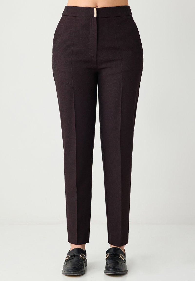 Pantalon noir sur mesure à taille haute, en tissu texturé, avec une fermeture éclair à l'avant. Coupe slim avec un design de jambe fuselée.