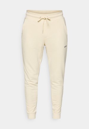 Cremefarvede sweatpants lavet af blødt stof, med elastisk talje og snøre, sidelommer og ribbede manchetter.