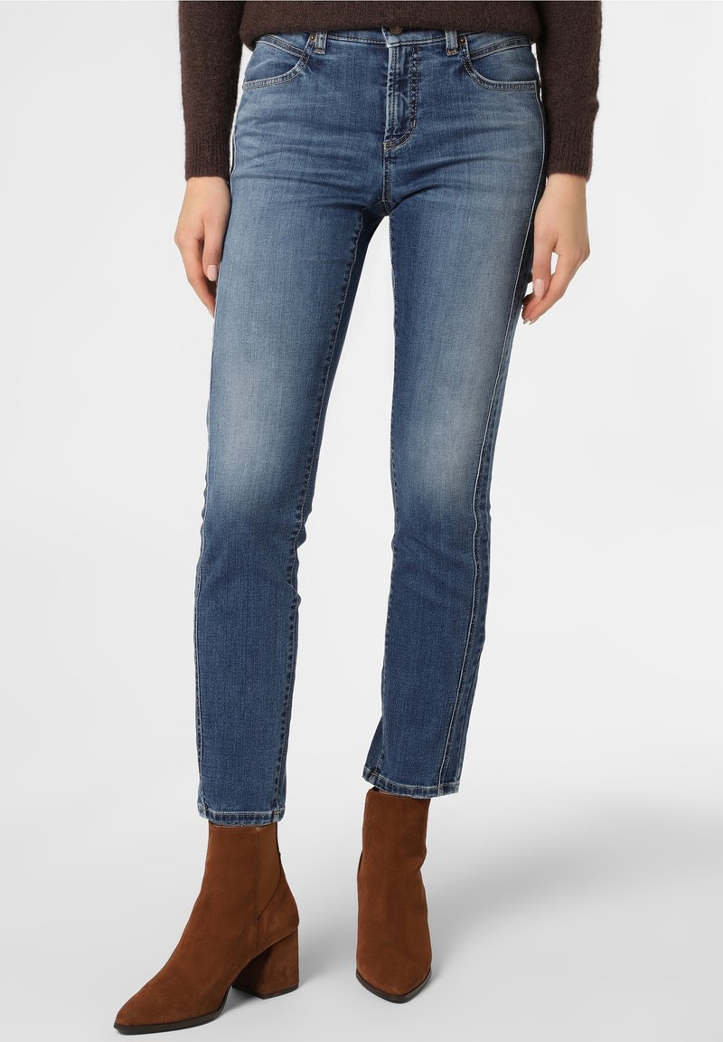 Blå denimjeans med mellan hög midja, slim fit och blekningsdetaljer, i kombination med bruna mocka ankelstövlar och en mörk tröja.