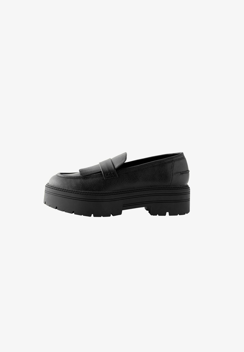 Black leather loafers with a textured surface, a prominent front strap, and thick, chunky rubber soles with pronounced tread patterns.