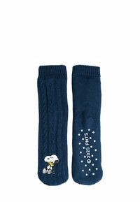 Calze lavorate a maglia blu navy con motivo a treccia, caratterizzate da un personaggio ricamato e un motivo a pois bianchi sulla suola.