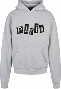 Szürke kapucnis pulóver, nagy fekete grafikával, amelyen a "Párizs" felirat található, az "i" betű részét képező stilizált Eiffel-toronyval. Elöl zseb található.