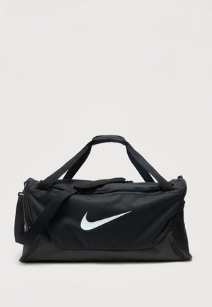 Sort Nike duffel taske med hvid swoosh-logo, dobbelte bærehåndtag, justerbar skulderrem og lynlåslommer på en ensfarvet baggrund.