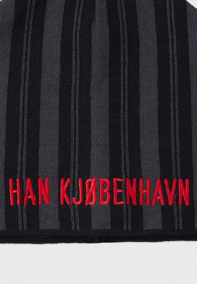 Čierna pletená čiapka s vertikálnymi sivými pruhmi. V dolnej časti s červeným vyšitým nápisom "HAN KJØBENHAVN". Mäkká textúra, rebrovaný dizajn.