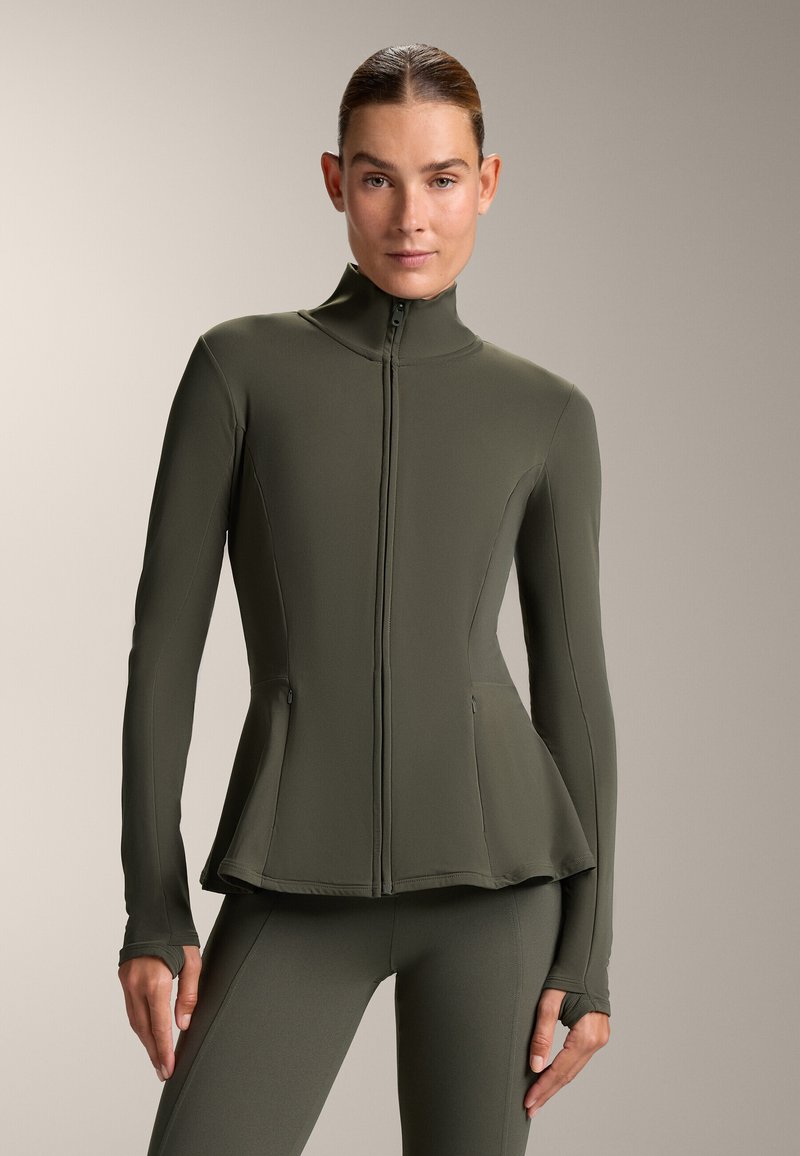 Athletic jacket in olive green, featuring a high collar, zip closure, fitted design, and side pockets. The material is smooth and stretchy.