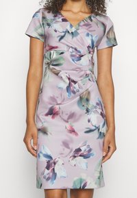 Blommig klänning i lavendel med korta ärmar, omslag design och r gathered detail vid midjan; har stora, färgglada blommönster.