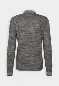 Pull en tricot gris et noir à manches longues, vu de dos, avec un col montant et des poignets ajustés.