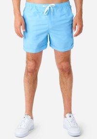 Pantaloncini da bagno azzurri chiari realizzati in tessuto morbido, caratterizzati da una vita elastica con cordoncino, tasche laterali e orlo risvoltato.