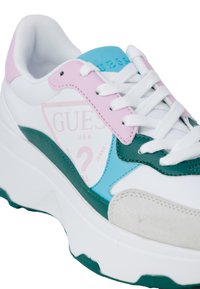 Sneaker bianca con suola chunky. Dettagli in pelle teal, rosa e verde. Presenta branding ricamato e accenti testurizzati.