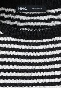 Pull en maille rayé noir et blanc avec col rond côtelé et étiquette de la marque MNG à l’intérieur du col indiquant la taille EU-USA-S/MEX-CH.