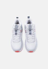 Ζευγάρι λευκά παπούτσια για τρέξιμο Columbia με γκρι και κόκκινες αποχρώσεις, επάνω μέρος από δίχτυ και κορδόνια, από πάνω, σε λευκό φόντο.