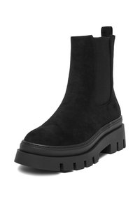 Bota de tobillo de ante negro con paneles laterales elásticos, suela de plataforma de goma gruesa y un tacón robusto. Textura suave con detalles de costura mínimos.