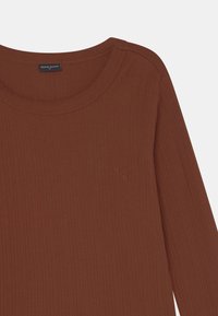 Camisola de manga longa castanha, com decote redondo e detalhe em logótipo em relevo no canto inferior esquerdo. Tecido macio e texturizado.