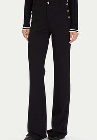 Czarne rozszerzane spodnie wykonane z gładkiej tkaniny, z ozdobnymi złotymi guzikami po boku i wysokim stanem.