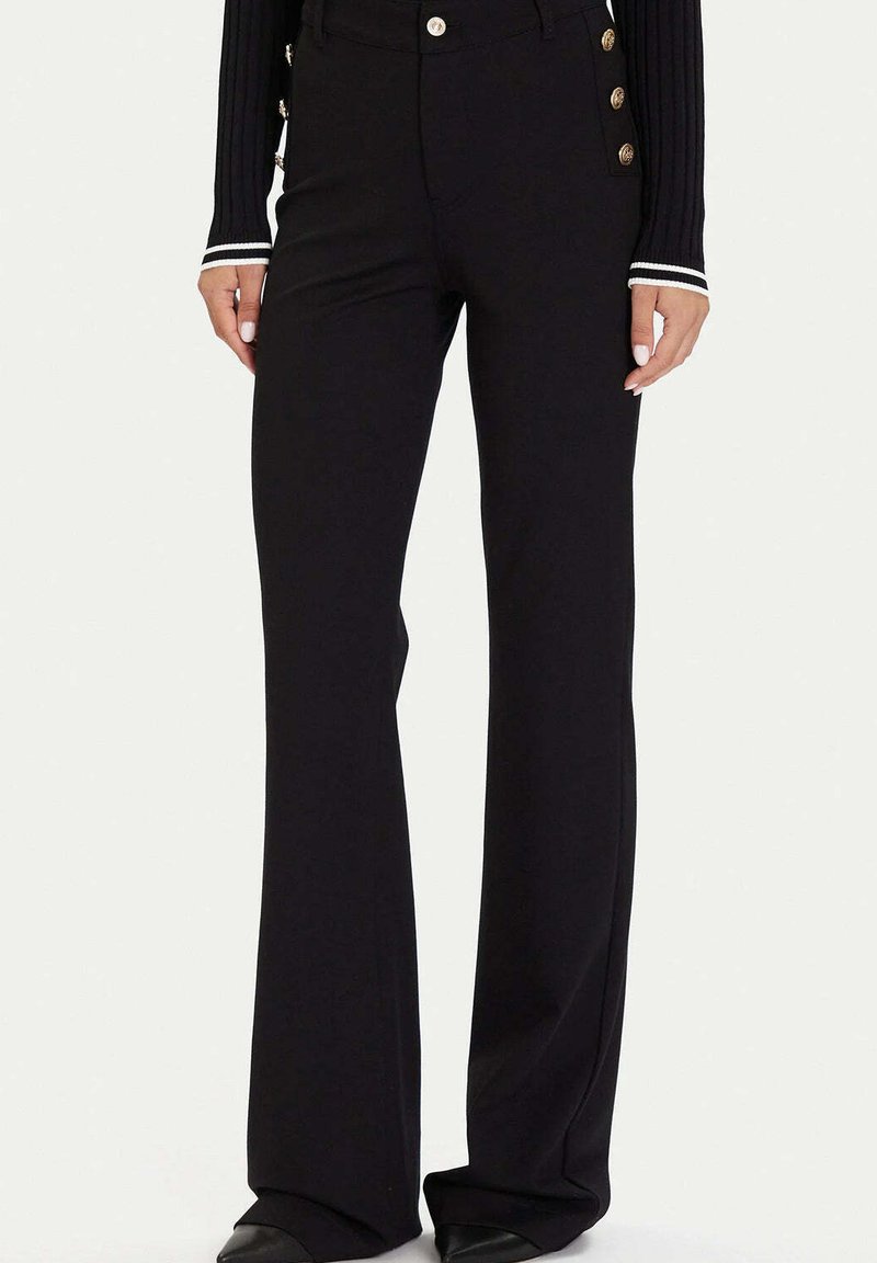 Czarne rozszerzane spodnie wykonane z gładkiej tkaniny, z ozdobnymi złotymi guzikami po boku i wysokim stanem.