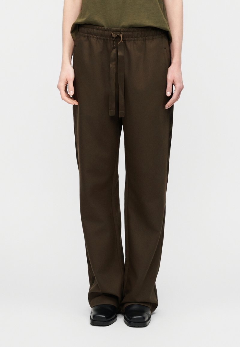 Σκούρο καφέ παντελόνι με φαρδιά μπατζάκια, ελαστ ική μέση, κορδόνι σύσφιξης και πλαϊνές τσέπες. Λείο ύφασμα; άνετη εφαρμογή.