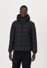 Sort puffer jakke med hætte, med kviltet design, lynlås foran og sidelommer, lavet af kuldebestandigt materiale.