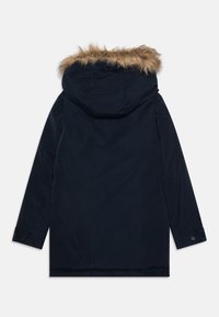 Navy parka with a removable fur-lined hood, long sleeves, buttoned cuffs, and a straight cut. Smooth fabric with a matte finish.