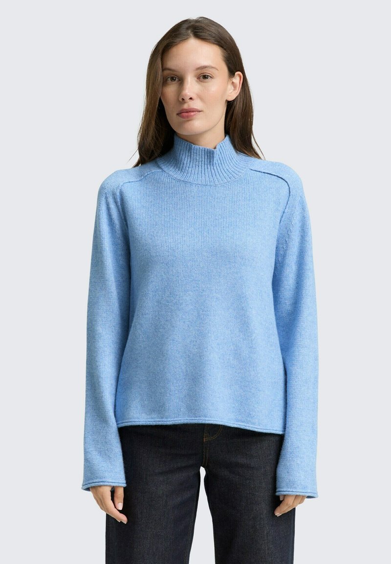 Hellblauer Pullover aus weichem Strickmaterial, mit einem hohen gerippten Rundhalsausschnitt, langen Ärmeln und einem lockeren Schnitt mit Seitennähten.
