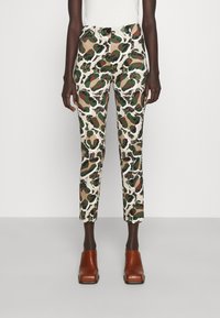 Pantalon au design ajusté avec un motif camouflage multicolore dans des teintes de vert, marron et crème, doté de poches avant et d'une fermeture à bouton.