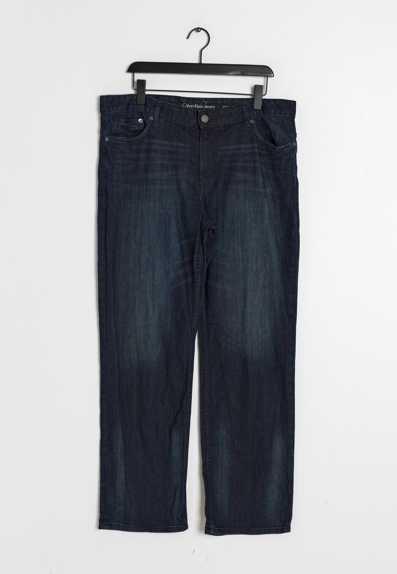 Blå denimjeans med rak passform, som har en klassisk femfickdesign och subtila slitageeffekter på låren, upphängda på en galge.