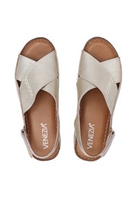 Sandales à brides croisées en cuir métallisé argenté avec un semelle en cuir brun. Comprend des détails de couture et une sangle à boucle sur le côté pour un ajustement sécurisé.