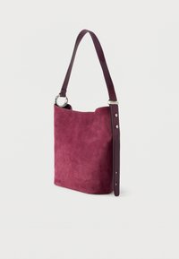 Semišová kabelka v hlbokom bordovej farbe s hladkým koženým remienkom a striebornými kovaniami, ktorá sa vyznačuje jemnou textúrou a štruktúrovaným tvarom.