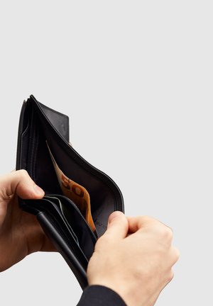 Portafoglio in pelle nera aperto che mostra una banconota da 50 euro e molteplici scomparti per carte, caratterizzato da una texture liscia e una chiusura con zip.